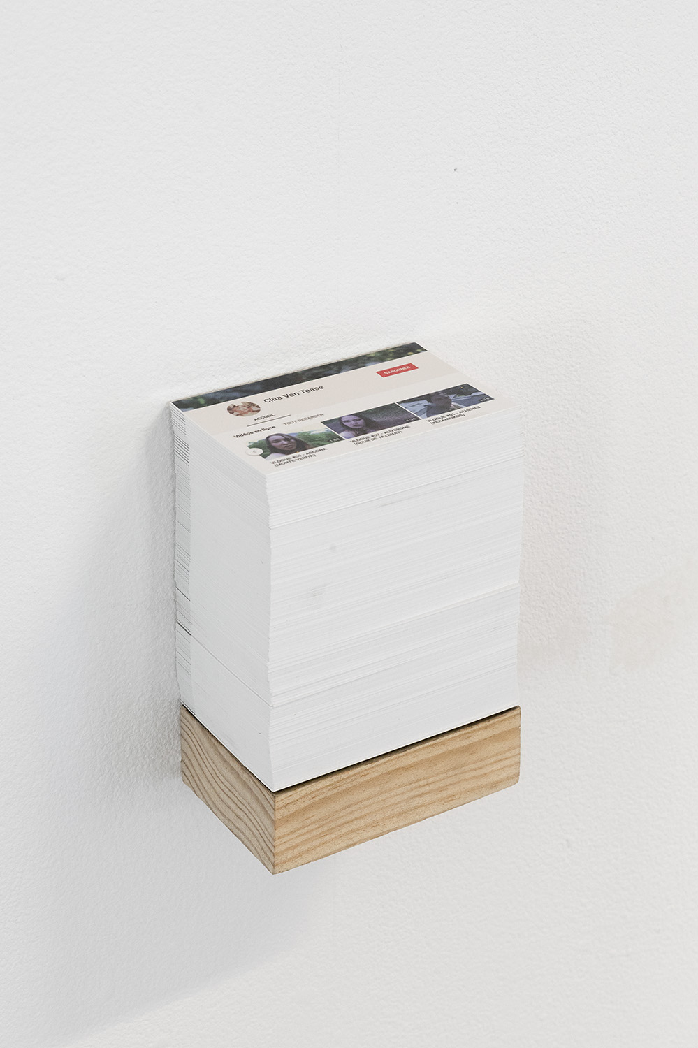 pile de cartes de visite qui reprend les codes de la page d'accueil Youtube. L'étagère qui porte la pile est à la taille exacte des cartes, ce qui fait une très haute pile sur une petite étagère.